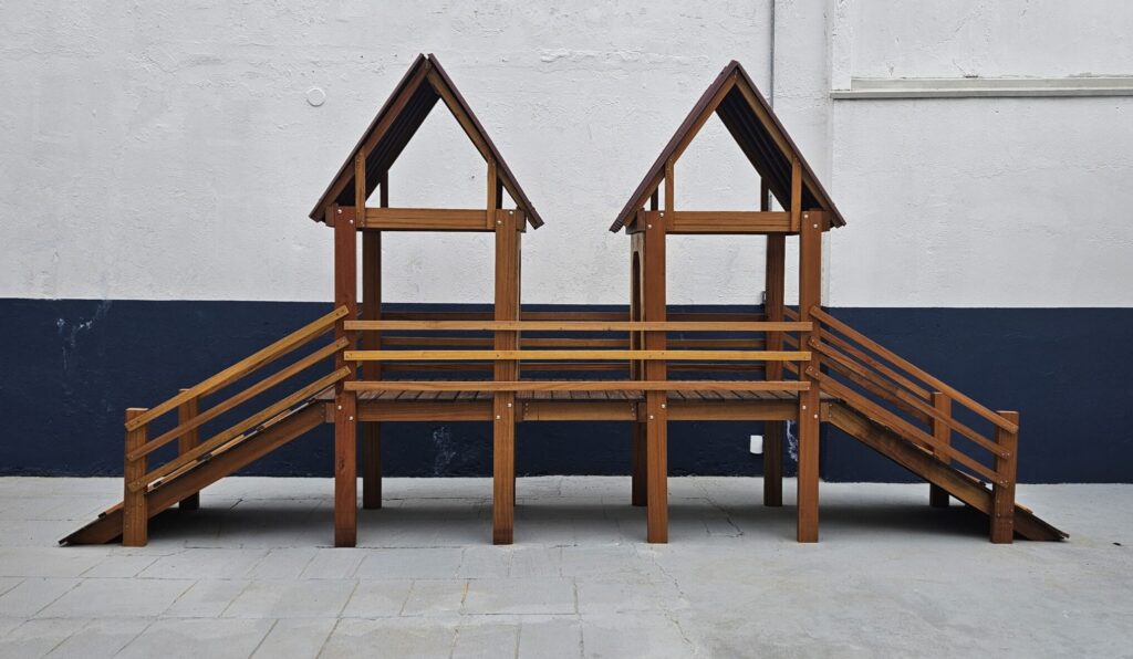 Foto com parede de fundo metade branca e metade azul, com um brinquedão para cães correrem em madeira envernizada na frente